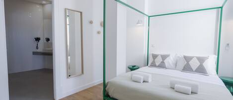 Un dormitorio moderno con cama con dosel, dosel de marco verde y suelo de madera.
