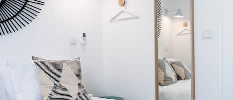 Una camera da letto moderna con un letto, uno specchio grande e un lampadario a parete.