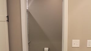 Une salle de bain avec des toilettes, une douche et un lavabo.