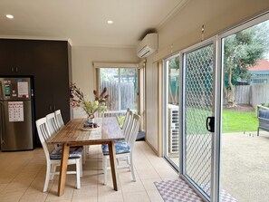 A kitchen with a dining table, chairs, and a refrigerator. - Whites Retreat (The Esplanade) (Torquay)