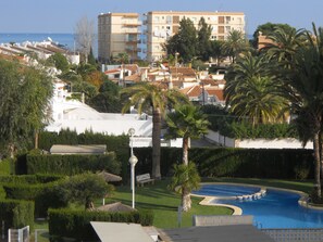 Ein Resort mit Schwimmbad, Palmen und Meerblick.