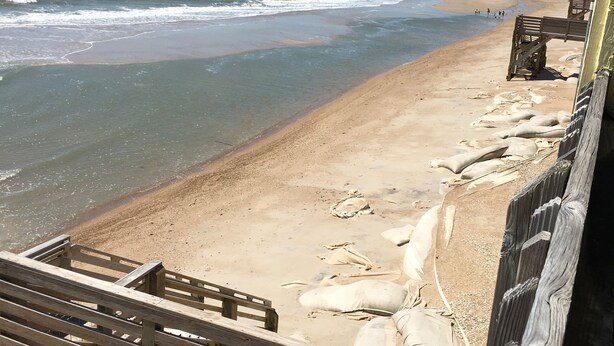 Una playa con pasarelas y bancos de madera.