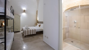A hotel room with a bed, a wardrobe, a shower area, and a small seating area. - Casale Donna Rosa (Sannicola)