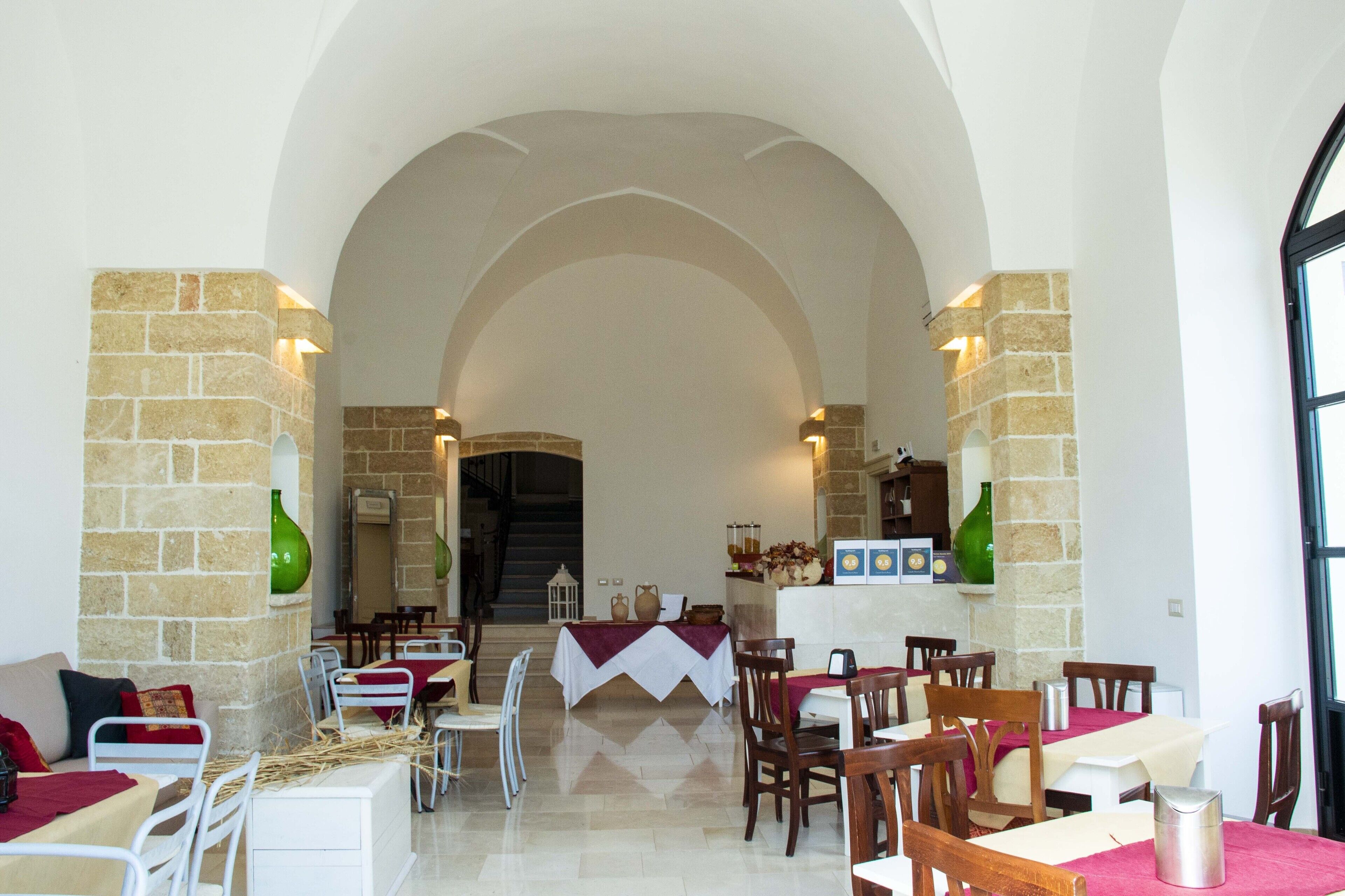 A restaurant with an arched ceiling, stone walls, and tables set for dining.