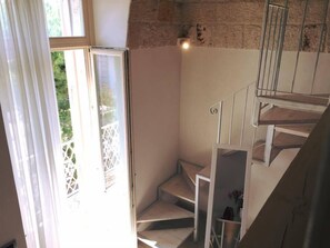 A staircase with a white railing and a view of greenery outside. - Cantaluna B&B (Polignano a Mare)