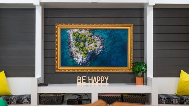 A framed artwork of an island with a "BE HAPPY" sign below it.