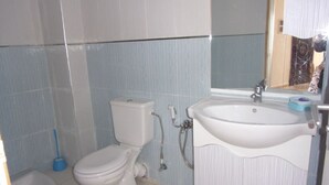 Een badkamer met toilet, bidet en wastafel.