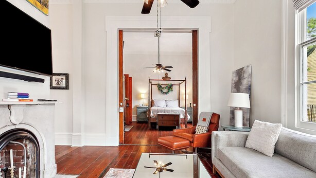 A living room with a fireplace, a sofa, a coffee table, and a TV. - New Orleans charm with Gated Parking! (New Orleans)