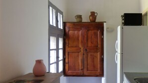 Una cocina con armarios de madera, un refrigerador blanco y piso de baldosas.
