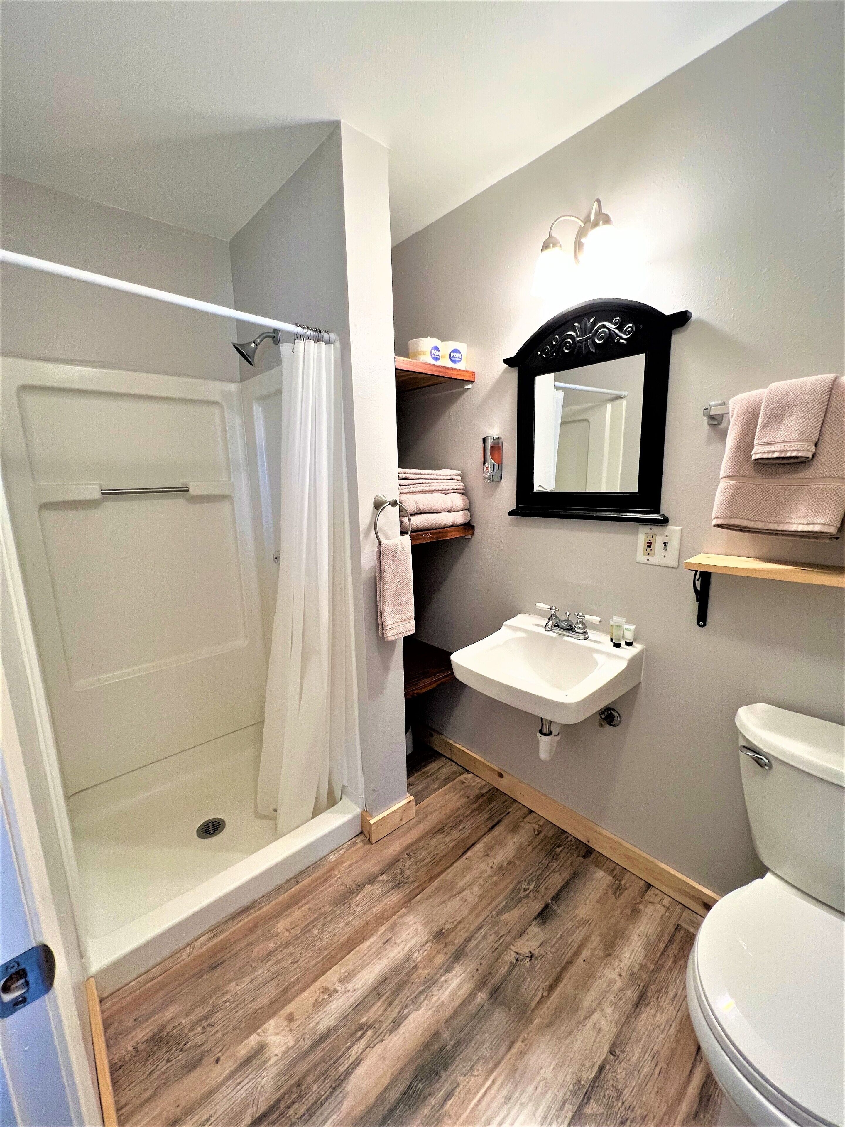 Une salle de bain équipée d’une douche, d’un lavabo, de toilettes et d’un miroir.