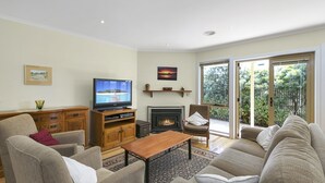 A living room with a television, fireplace, and seating area. - Cavalier (Zeally Bay Rd): 4  BR, 2  BA House in Torquay, Sleeps 9 (Torquay)
