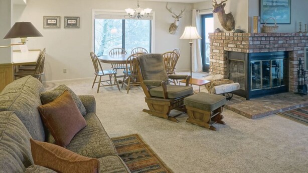 A cozy living room with a fireplace, a dining table, and comfortable seating. - June Lake Interlaken 12 Cozy, Spacious (June Lake)