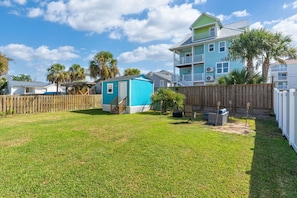 A residential area with a blue house, a wooden fence, and a grassy yard.