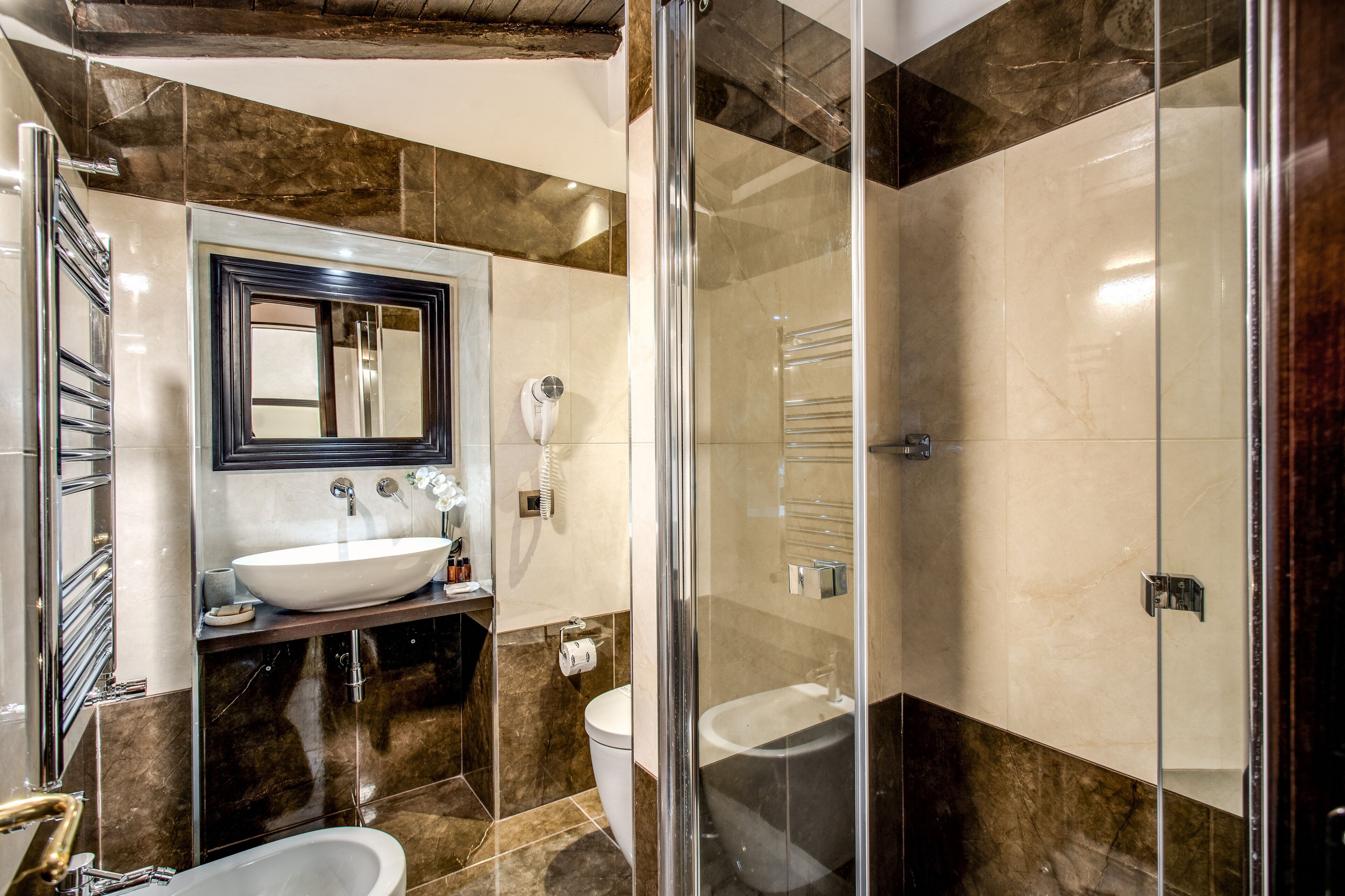 Een moderne badkamer met een grote spiegel, een wastafel, toilet en een douchecabine met glazen wanden.
