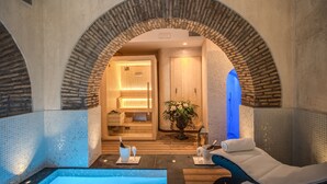 Un área de spa con piscina, suelo de madera y un arco de piedra.