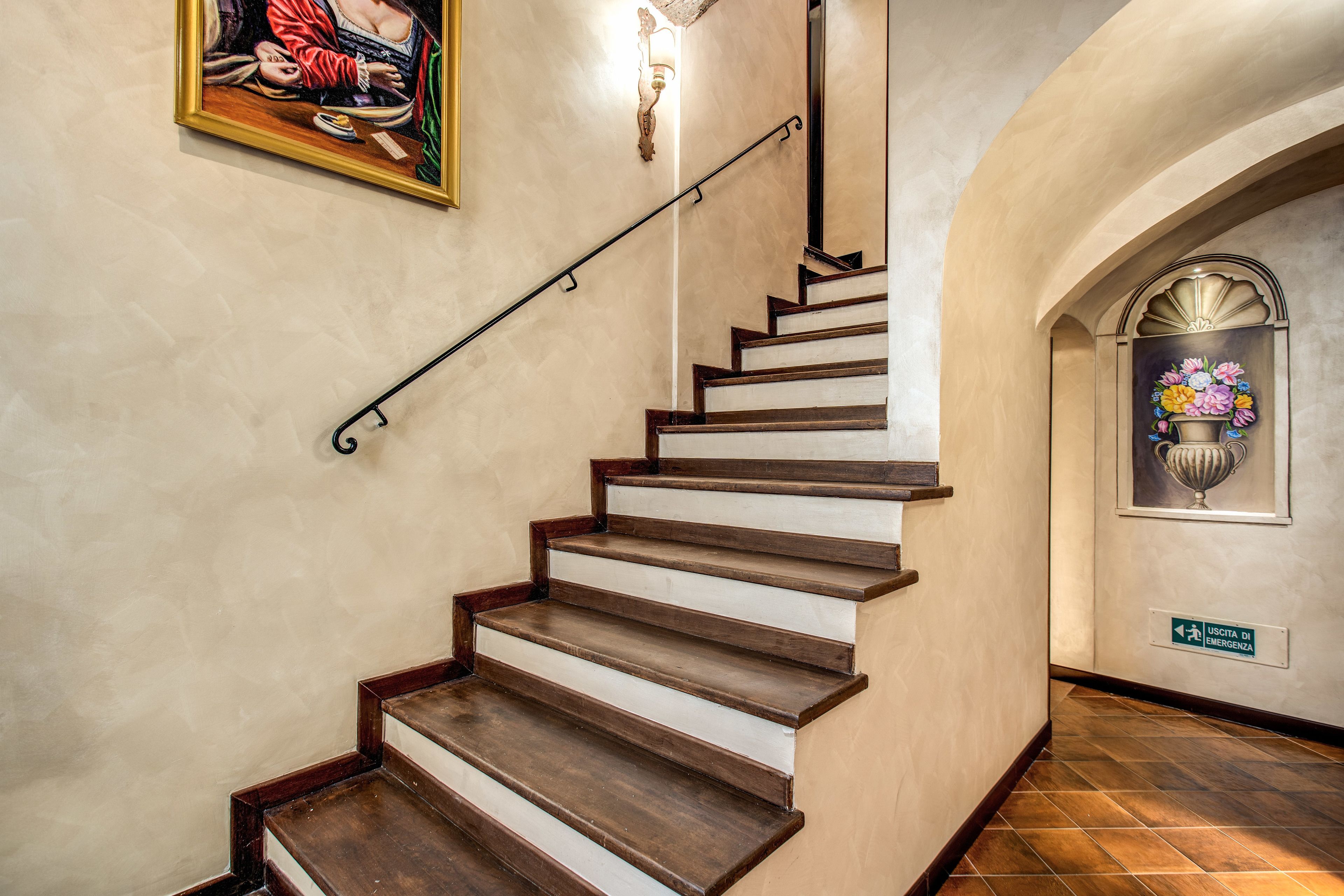 A staircase with wooden steps and a metal handrail, leading to an upper floor.