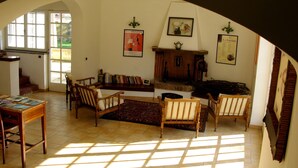 Uma sala de estar aconchegante com lareira, estantes de livros e espaço de jantar.