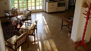 Uma sala de estar espaçosa com uma grande janela, televisão e um espaço para refeições.