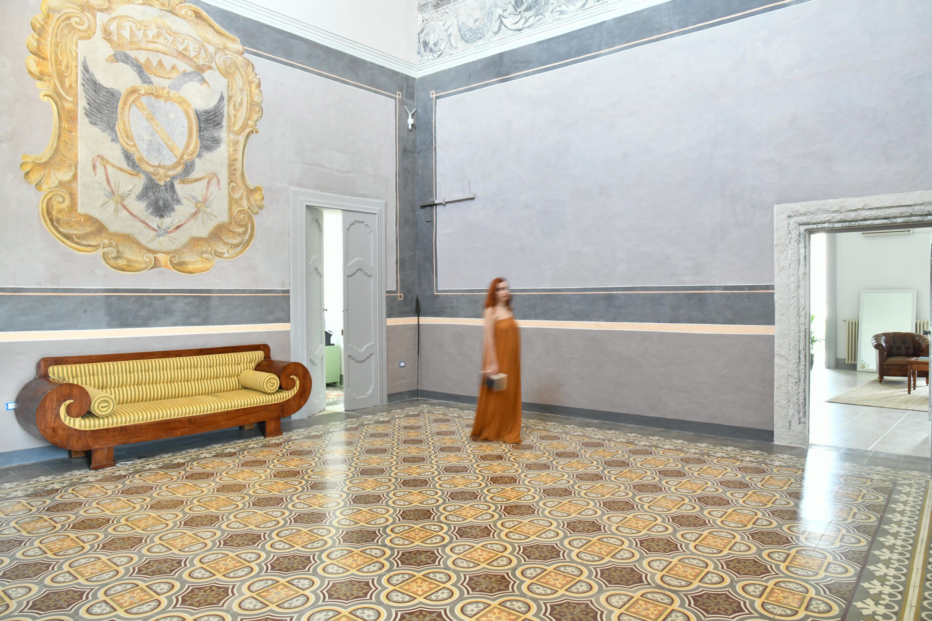 Eine großzügige Lobby mit strukturiertem Bodenbelag, einer hölzernen Bank und einem großen Wandkunstwerk.