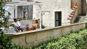A stone building with a white pergola and outdoor seating area. - Dimora Duchessina (Minervino di Lecce)