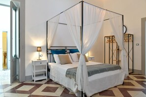 A neatly arranged bedroom with a four-poster bed, a bedside table, and a nightstand. - Dimora Duchessina (Minervino di Lecce)
