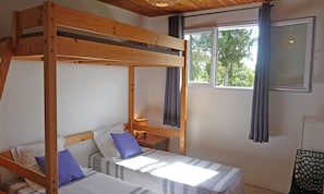A bunk bed room with a window and curtains.