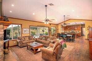A spacious living room with a fireplace, a dining area, and a kitchen with wooden cabinets.