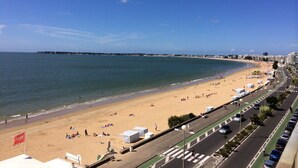 A coastal road with a beach and ocean on one side, and a cityscape with buildings and a road on the other. - House with garden, 8 minutes Beach LA BAULE, residence with swimming pool (Guérande)