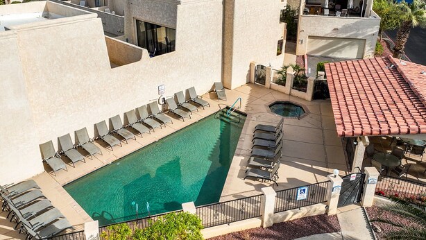 Ein Pool auf dem Dach mit Liegestühlen, einem Whirlpool und einer Terrassenfläche mit Tischen und Stühlen.