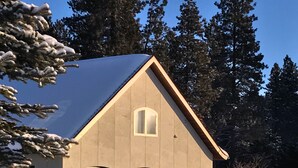 Ein Haus mit schneebedecktem Dach und drei Garagen.