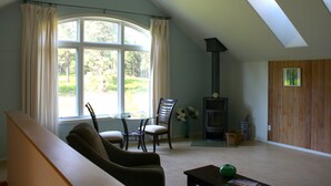 Ein geräumiges Wohnzimmer mit großem Fenster, Kamin und gemütlicher Sitzecke.