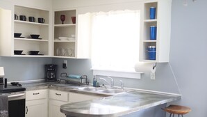 A kitchen with white cabinets, a double sink, and a window with sheer curtains. - Spacious 2 Bedroom Home within 8 Minute walk to Downtown Augusta (Augusta)