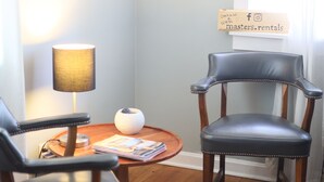 A room with two leather chairs, a small table with a lamp, a decorative item, and a framed picture on the wall. - Spacious 2 Bedroom Home within 8 Minute walk to Downtown Augusta (Augusta)