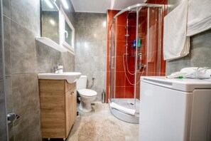 Deluxe appartement (Corona) | Badkamer | Een douche, een regendouche, een haardroger, pantoffels