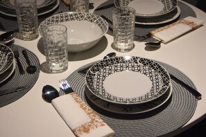 A table set with plates, glasses, cutlery, and a napkin. - Comely Luxury Apt Must (Thessaloniki)