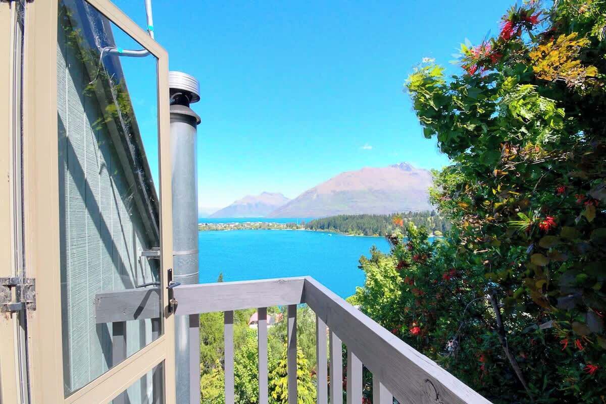 A view from a balcony overlooking a lake with mountains in the background.