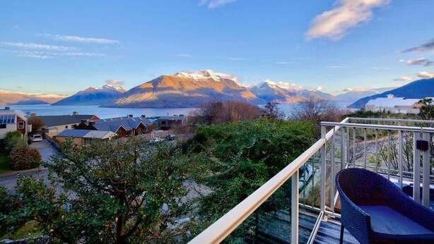 Un balcon avec vue sur les montagnes et un plan d’eau.