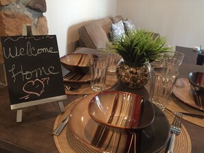 A dining table set with plates, cutlery, and a sign that reads "Welcome Home".