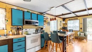 A modern kitchen with blue cabinets, a white stove, and a dining area with wooden chairs. - River Front Cabin in Plain, close to Lake Wenatchee

Short term rental #000168 (Leavenworth)