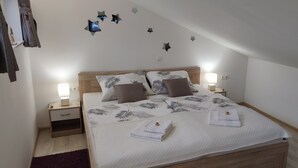 Une chambre à coucher avec un lit, des tables de chevet, une lampe et des décorations murales en forme d’étoiles.