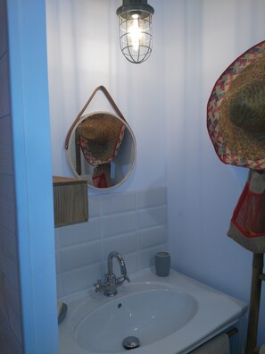 Bathroom features a sink, mirror, and towel rack.