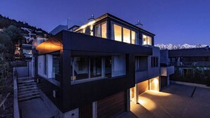 A modern two-story building with large windows and a staircase leading to the entrance.