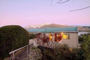 A modern house with a mountain backdrop.