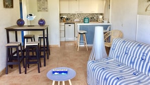 A compact living space with a dining area, kitchen, and a sofa.
