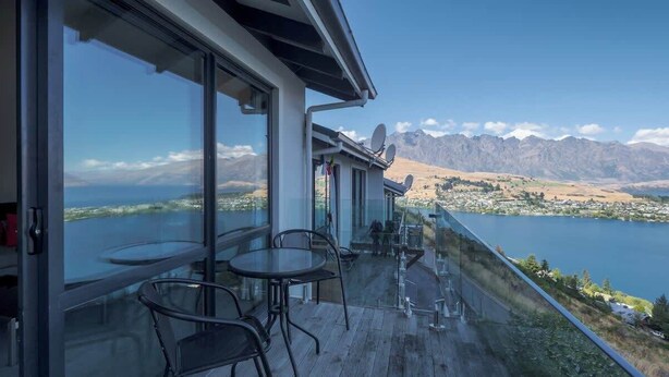 Un balcon avec vue sur un lac et des montagnes.