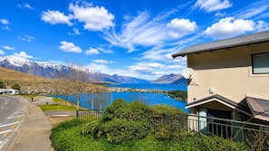 A residential building with a view of a lake and mountains.
