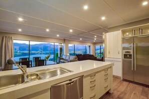 Enjoy cooking in this well-lit kitchen with a large island, stainless steel sink, and expansive views.