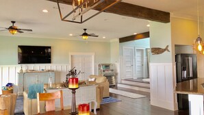 A spacious living area with a wooden floor, a dining table, and a kitchen area with a refrigerator. - A Santa Rosa Sound Waterfront home on 2 acres with a private beach and 200’ dock (Mary Esther)
