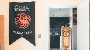 Eine Küche mit einem schwarzen Banner an der Wand, einer weißen Tür und einem Schrank mit einer Uhr.