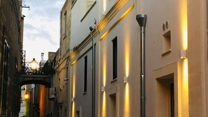 A narrow cobblestone street flanked by buildings with illuminated underglow lighting. - Casa Magadè (Manduria)